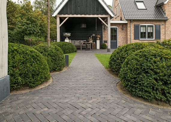 Een tuinpad van Vandersanden Carbona Antica klinkers in een landelijke tuin
