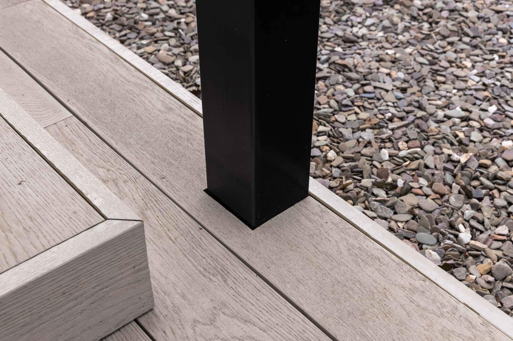 Detail van de aansluiting van vlonderplanken en tegels