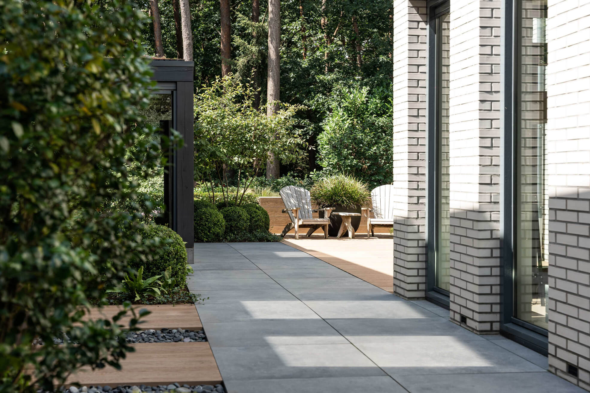 Tuinpad langs de woning met beplanting en vlondergedeelte