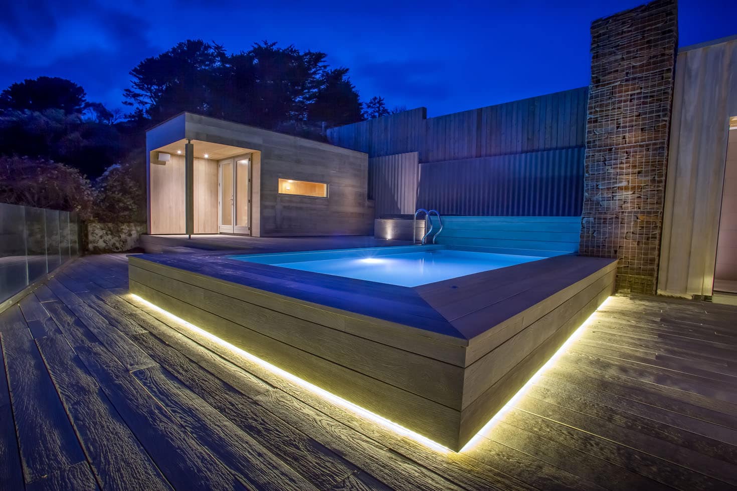 Verlicht verhoogd terras met zwembad bij de kustwoning