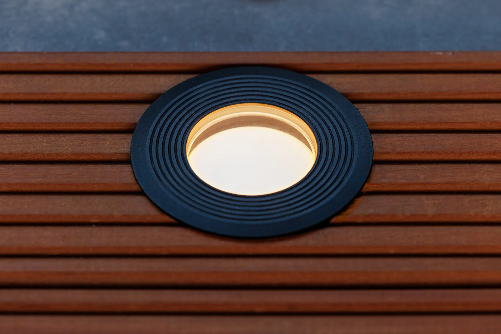 Een Lightpro Onyx grondspot in een houten vlonder